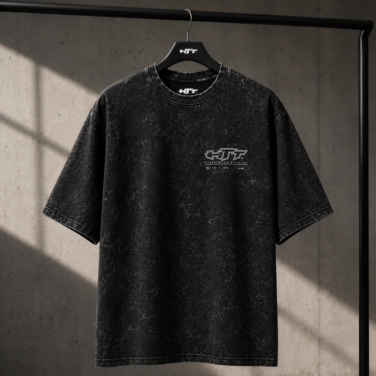HTT.002 Global Division Oversize-T-Shirt – Vorderseite auf einem Bügel mit HTT-Brustlogo