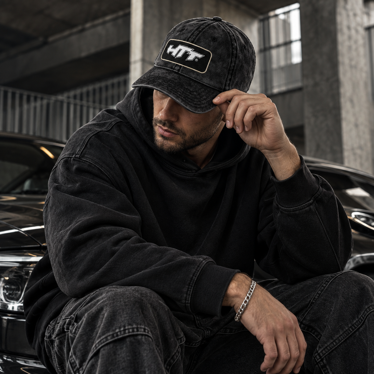 Mann mit der HTT 005 Washed Badge Cap im schwarz verwaschenen Streetwear-Stil