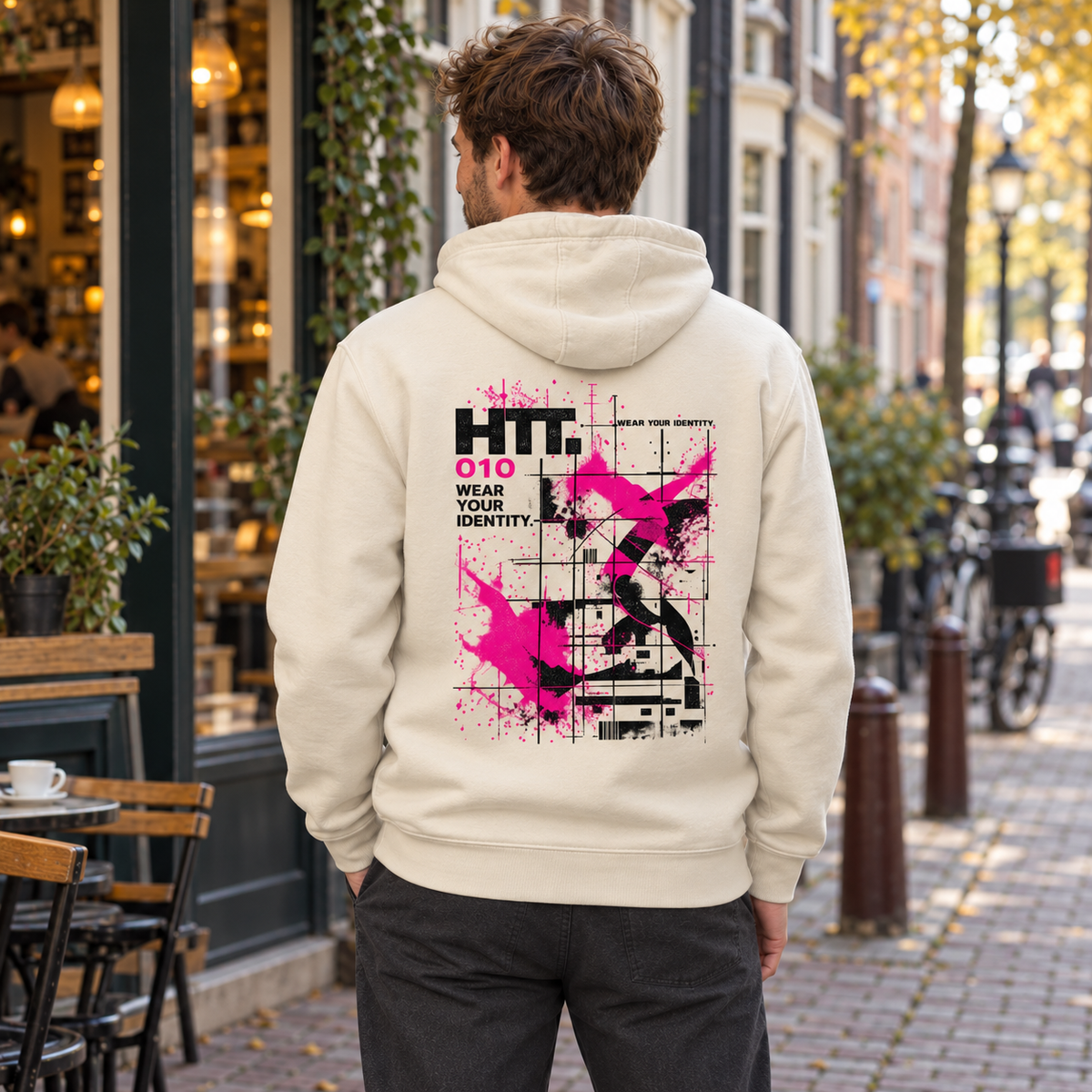 Achteraanzicht van de HTT.010 Bone Cream hoodie met zwarte en felroze Industrial Identity backprint.