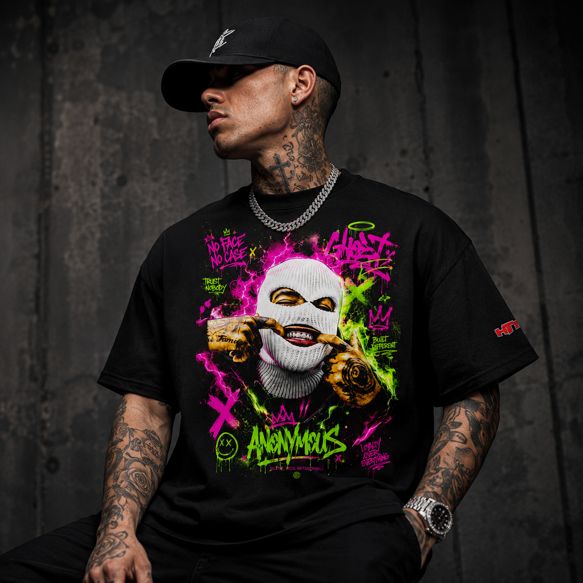 Camiseta de streetwear negra HTT Anonymous lucida por un modelo masculino tatuado