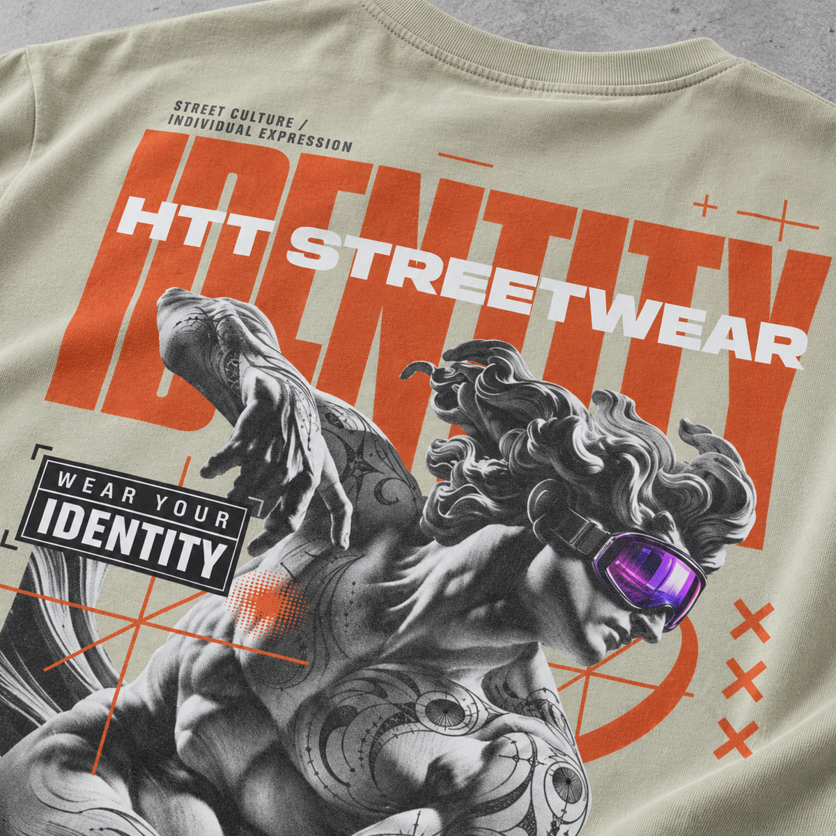 Close-up visual of the HTT Identity Sculpt back print in Pastel Gray, showing the purple goggles, tattoos and orange lettering.