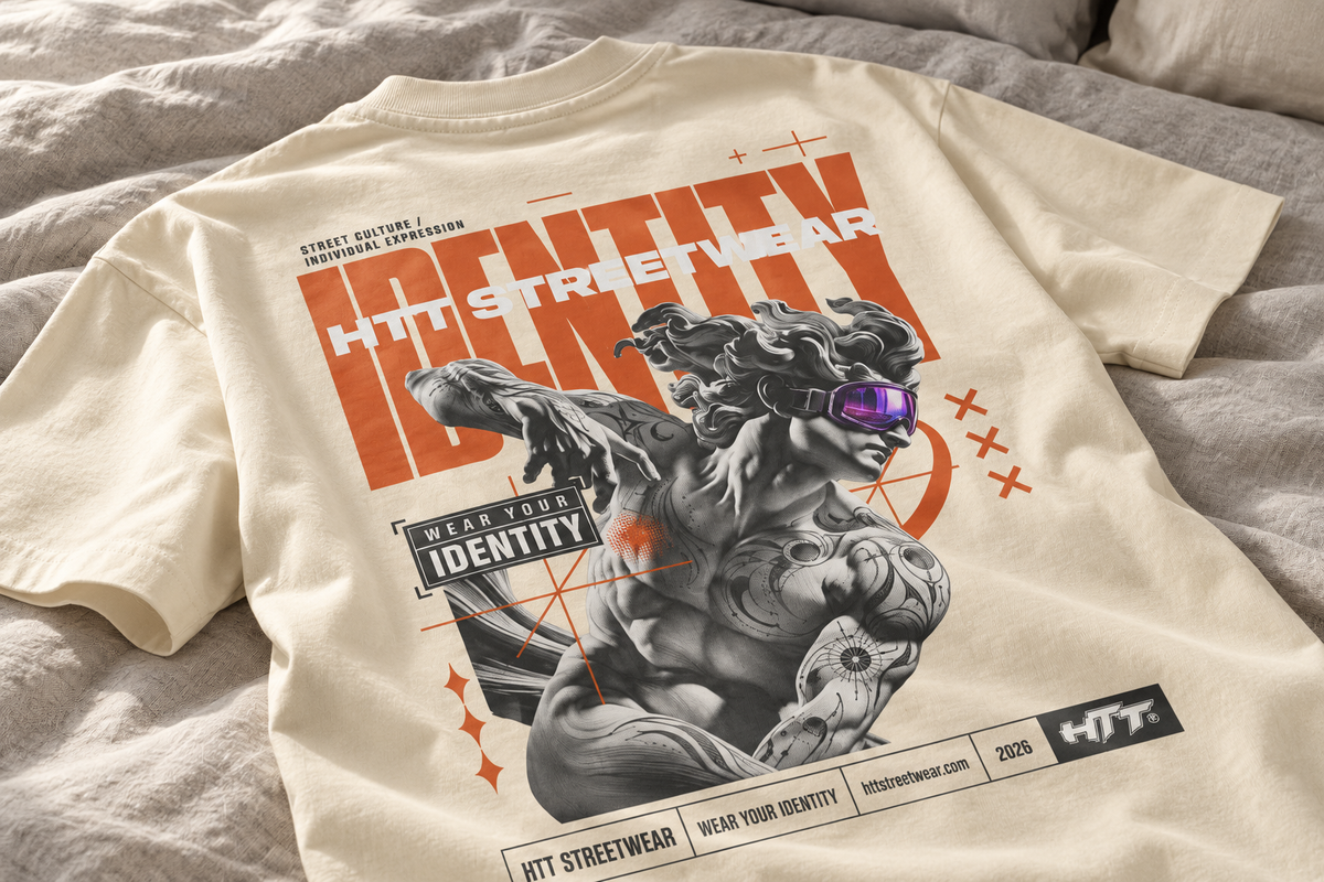HTT Identity Sculpt T-shirt in White Rock cream laid on a bed, close-up visual of the back graphic with purple goggles.