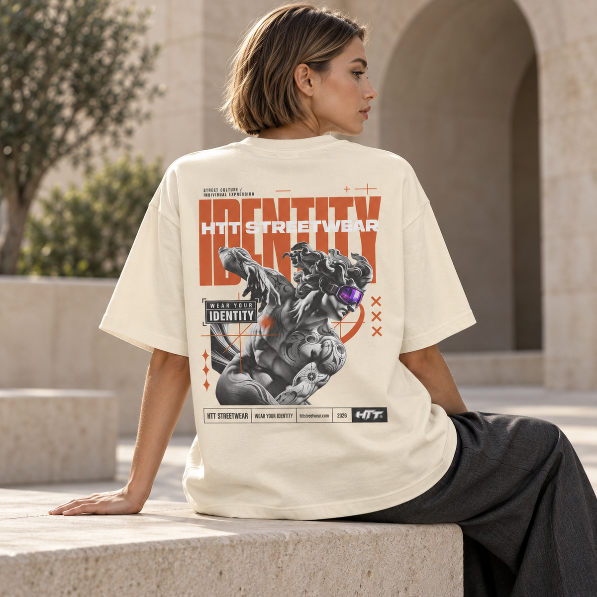 HTT Identity Sculpt oversized T-shirt in White Rock cream, back graphic shown on a seated digital female model.