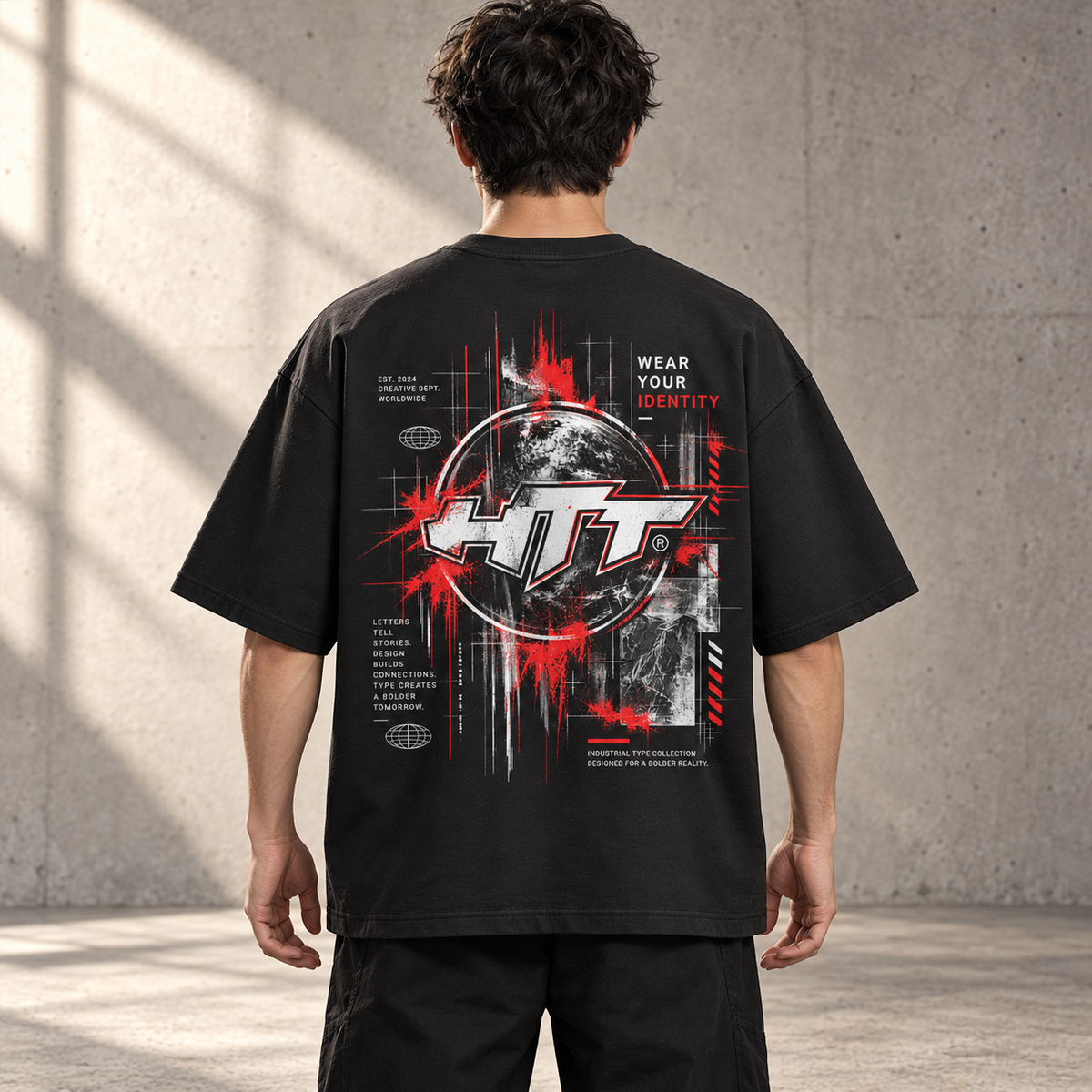 Achterkant van het zwarte HTT Industrial World boxy T-shirt op een model, met rood-witte wereldbolprint en Wear Your Identity.