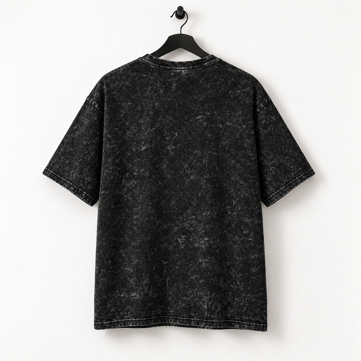 Onbedrukte achterkant van het HTT Open Your Eyes oversized T-shirt in washed black aan een zwarte hanger tegen een lichte achtergrond.
