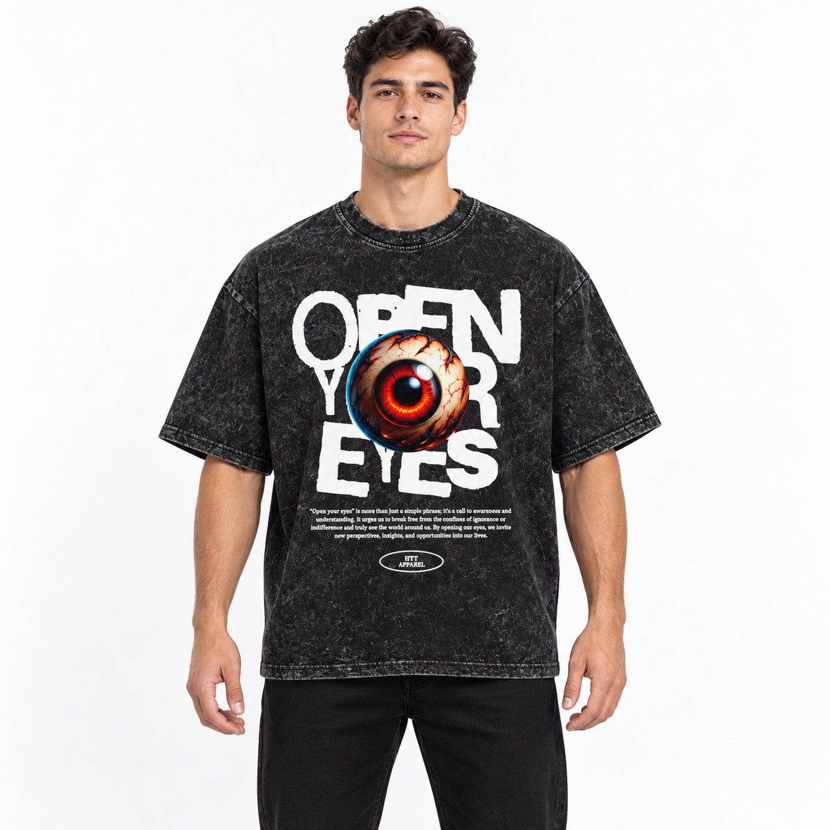 Man draagt het HTT Open Your Eyes oversized T-shirt in washed black met witte tekst en rode oogprint tegen een lichte achtergrond.