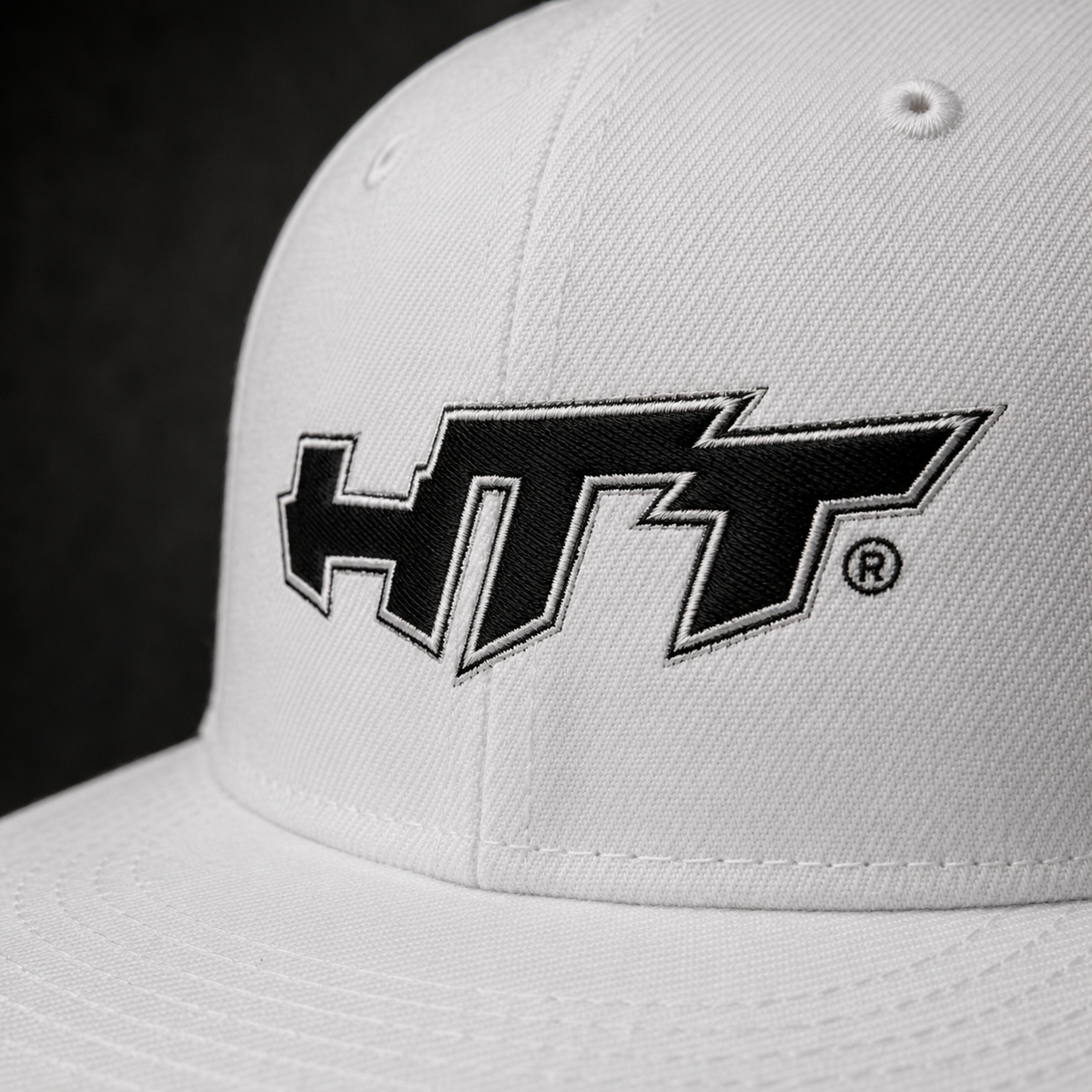 Close-up of HTT logo embroidery on white Signature Snapback