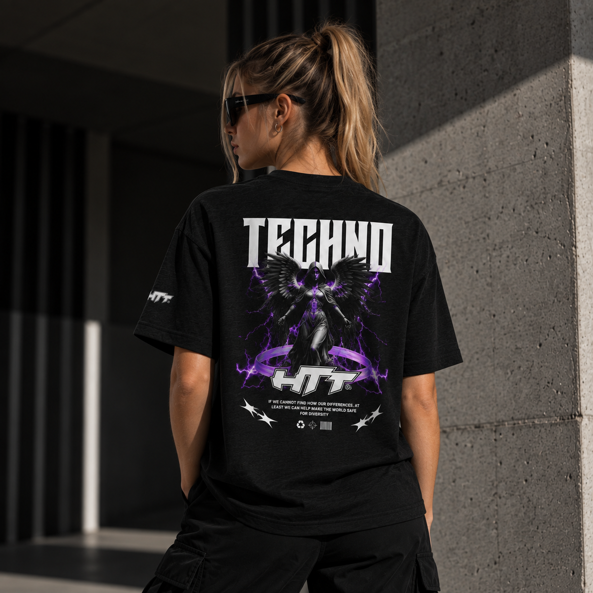 Vrouwelijk model toont achterkant van zwart HTT Techno Angel T-Shirt met paarse engel-backprint